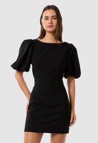 Abito aderente nero con maniche a palloncino, scollatura rotonda e tessuto strutturato. Presenta un design senza cuciture che esalta la silhouette.