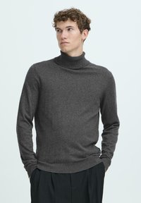 Mørkegrå genser med høy hals laget av myk stoff, med ribbet krage og mansjetter, i en tettsittende silhuett og lange ermer.