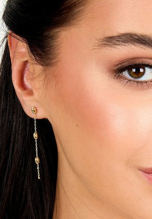Goldene Ohrstecker mit ovalen Perlen, die ein zartes Design aufweisen, das in der Länge fällt. Glatte Oberfläche und glänzende Ausführung.