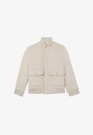 Jasnobeżowa wełniana kurtka z wysokim prążkowanym kołnierzem, dwoma przednimi kieszeniami z patkami zapinanymi na guziki oraz prążkowanymi mankietami i dołem.