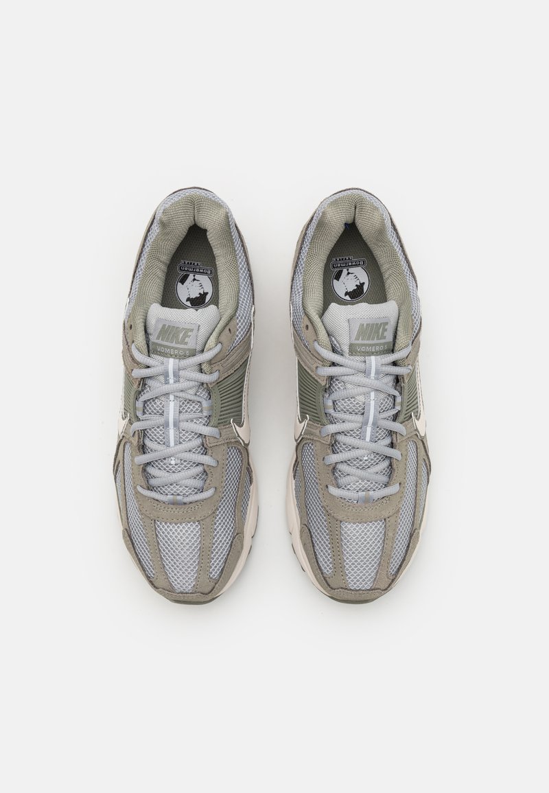 Sneakers Nike Vomero z siateczkową i syntetyczną cholewką w kolorze szarym i jasnozielonym, z białymi akcentami, okrągłymi sznurówkami i wyprofilowanym językiem.