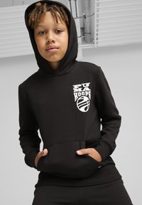 Juodas megztinis su gaubtu, pagamintas iš minkštos medžiagos, su priekinėmis kišenėmis ir baltu "PUMA HOOPS" logotipu kartu su krepšinio grafika krūtinėje.