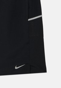 Μαύρο αθλητικό σορτς από αεριζόμενο ύφασμα, με διάτρητη υφή στο πλάι και ασημένιο λογότυπο Nike Swoosh στο τελείωμα.