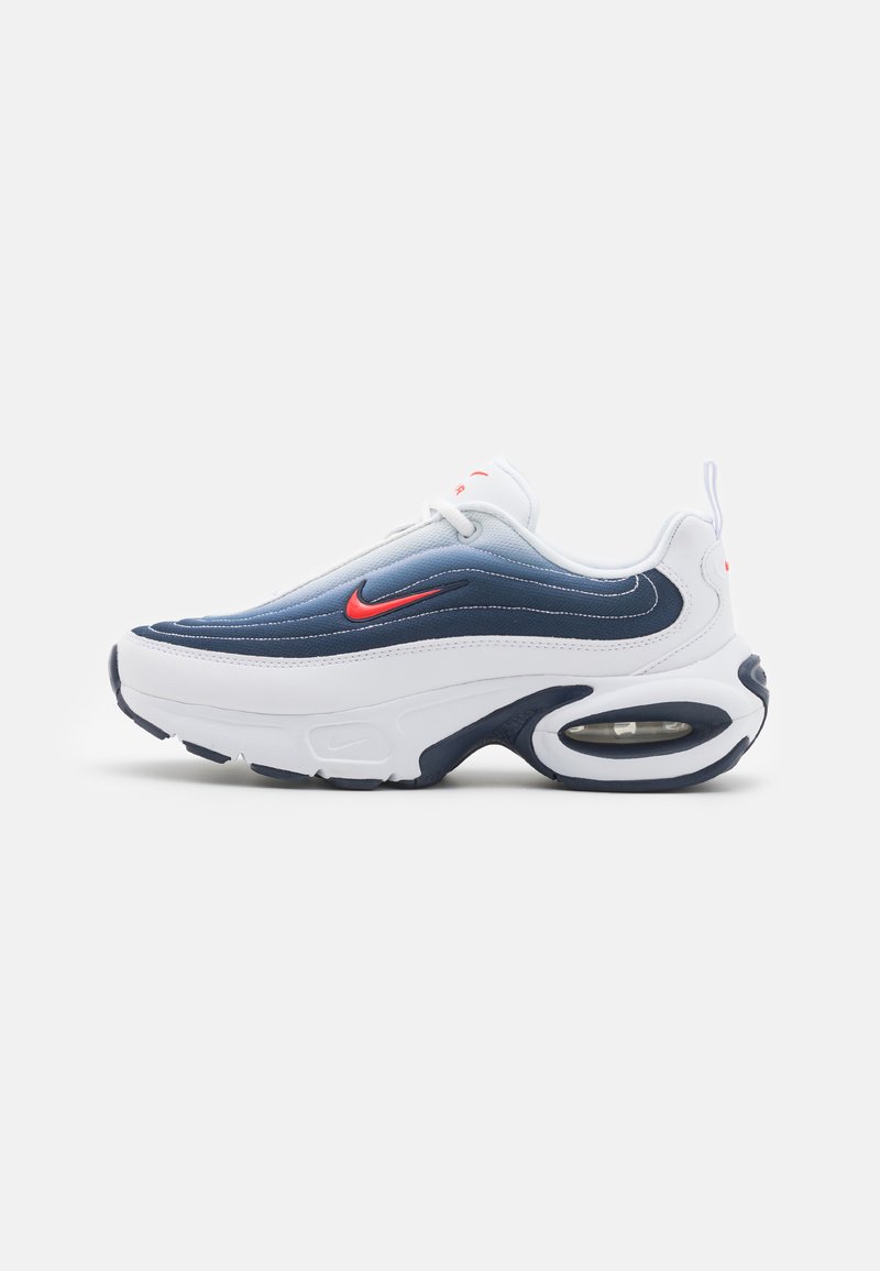 Balti ir tamsiai mėlyni sportbačiai su bangos formos dizainu, turintys raudoną Nike logotipą, paminkštintą liežuvėlį ir matomą oro pagalvėlę pado viduje.