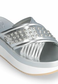 Sandale argentée à glissière, avec une large bride ornée de strass transparents, texture lisse et brillante, et une semelle à plateforme superposée.