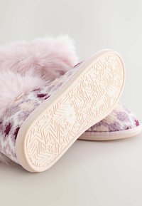 Kapcie z futerka ekologicznego w fioletowo-różowy wzór, zaokrąglonym noskiem i jasnoróżową gumową podeszwą z motywem gwiazdek na bieżniku.
