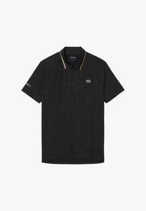 Camisa polo negra con un patrón geométrico texturizado, mangas cortas, acentos amarillos en el cuello y un logotipo verde en el pecho.