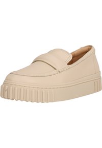 Beige läder slip-on sko med rund tå, vadderad rem och en tjock texturerad gummisula med horisontella spår.