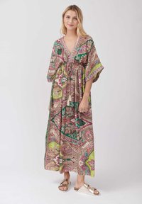 Robe maxi bohème multicolore avec des motifs paisley, décolleté en V, taille élastique, manches fluides et accents de franges décoratives.