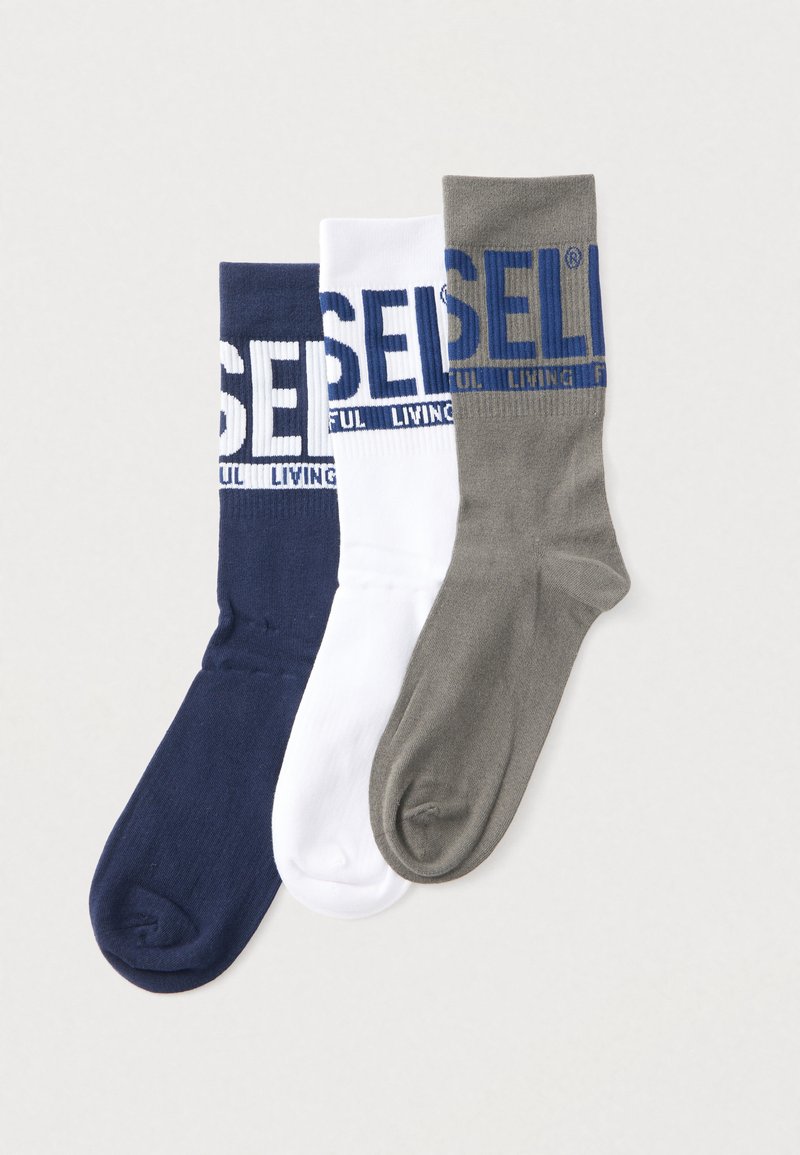 Drei Paar Socken: marineblau, weiß und grau. Jede hat eine gerippte Textur und zeigt "SELI" in fettem Druck am Bündchen.