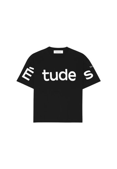 T-shirt noir à manches courtes en coton, arborant un grand texte blanc "Étude" sur le devant et "Studio" sur la manche gauche.