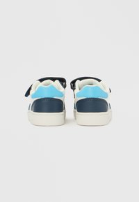 Adidași din piele albastră și bleumarin cu barete velcro, tălpi albe și accente texturate pe călcâi și pe părți.