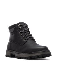 Botas de tobillo de cuero negro con un upper texturizado, diseño de cordones, collar acolchado y suela de goma resistente con profundas ranuras para tracción.