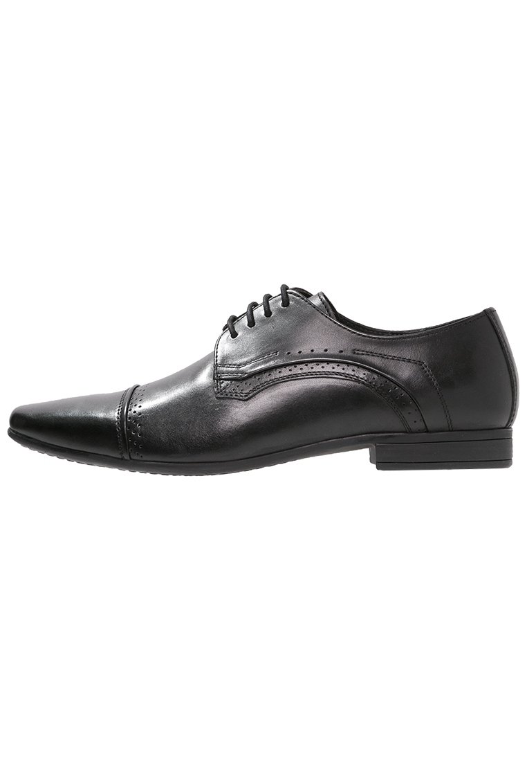 Chaussure habillée pour homme en cuir noir, à bout pointu, avec lacets, détails en brogue et petit talon empilé, vue de côté.