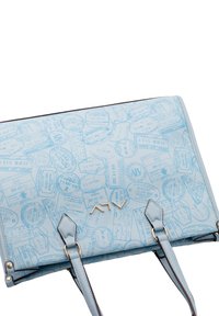 Borsa a tracolla blu chiaro con un motivo di timbri di viaggio, forma rettangolare, texture liscia, con hardware dorato e doppie spalline.