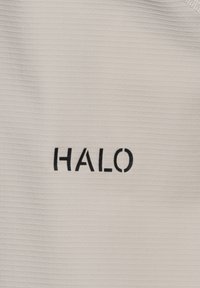 Hvidt tekstureret stof med ordet "HALO" trykt i sorte store bogstaver i midten.