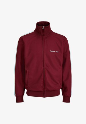 Vasakat värvi lukuga spordijakk valgete külgtriipude, kõrge krae, soonikkoes varrukasäärte ja alläärega ning tekstiga "Originals Studio" vasakul rinnal.