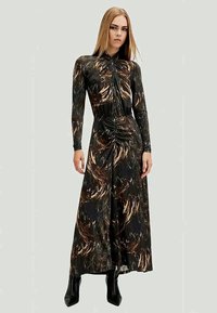 Robe longue noire avec un motif brun tourbillonnant, coupe ajustée, col haut, détail froncé à l'avant, manches longues, et fente jusqu'à mi-cuisse.