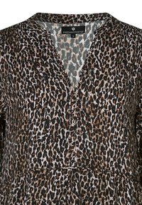 Blouse à imprimé léopard avec un décolleté en V, des boutons décoratifs et une coupe fluide dans des tons de noir, marron et crème. Tissu doux au toucher.