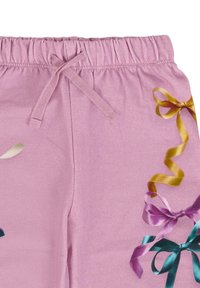 Roze katoenen joggingsbroek met een elastische tailleband, voorzien van kleurrijke lintafdrukken in geel, paars en blauwgroen aan één kant.
