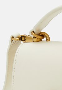 Borsa a tracolla in pelle bianca con forma strutturata, dotata di una chiusura e hardware in tono oro. Texture liscia con dettagli di cucitura ben visibili.