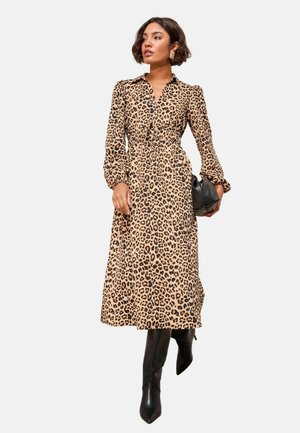 Beige- und schwarze Leopardendruck-Midi-Kleid mit kragenfreiem Ausschnitt, tailliertem Design und langen Puffärmeln, kombiniert mit kniehohen schwarzen Stiefeln.