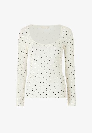 Hvid langærmet tætsiddende top med sorte polkaprikker og en bred, rund halsudskæring.