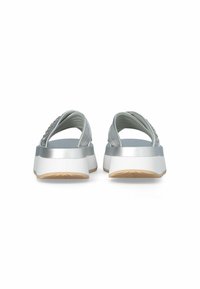 Sandales argentées avec un design à lanières croisées, semelle blanche épaisse et semelle extérieure en caoutchouc texturé. Des embellissements subtils soulignent les lanières.