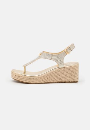 Gouden mesh wedge sandaal met een T-band ontwerp, zachte beige voetbed en geweven jute hak. Voorzien van een gesp sluiting op de enkelband.
