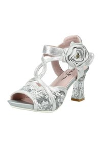 Sandale à talon haut argentée avec des brides pailletées, une décoration florale sur la bride de cheville et un talon bloc transparent texturé.