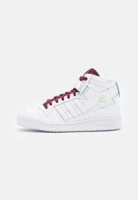 Vita högskor med burgundy snörningar, lädermaterial, vadderad krage, gulddetaljer och tre-stripes märke på sidan.