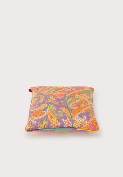 Coussin carré avec un motif paisley vibrant en orange, violet, vert et jaune sur un fond clair.