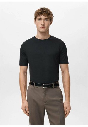 Čierne tričko s krátkym rukávom vyrobené z mäkkej látky, s okrúhlym výstrihom. Kombinované s hnedými nohavicami a čiernym opaskom. Jednoduchý, minimalistický dizajn.