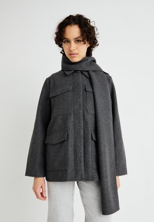 Manteau gris à double boutonnage avec un col haut, patte de boutonnage et quatre poches avant. Fabriqué en tissu texturé avec une écharpe attachée.
