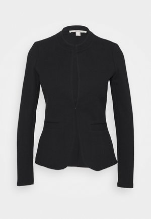 Blazer attillato nero con collo rotondo, tessuto textured e due tasche frontali. Presenta una chiusura con zip nascosta e maniche lunghe.