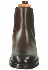 Brune skinn Chelsea-støvler med elastiske sidestykker, rund tå og en glatt overflate. Minimalt design med lav hæl og løkke på toppen.