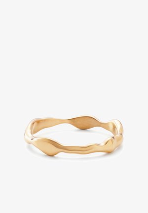 Armbånd i guldfarvet metal med et uregelmæssigt, bølget cirkeldesign og en glat, poleret overflade.