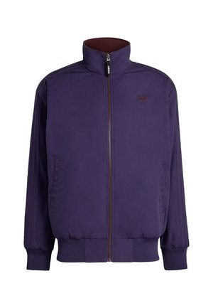 Chaqueta morada con cremallera y cuello alto, puños y dobladillo acanalados, con dos bolsillos laterales y un logotipo bordado en el pecho.