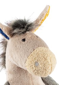 Plush donkey toy with beige fur, fuzzy cream snout, tufted dark mane, and lined ears—yellow with white patterns and solid blue.