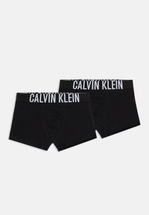 Dve čierne boxerky Calvin Klein s bielymi pásmi s logom, položené na bielom pozadí.