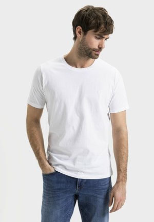Witte T-shirt met korte mouwen, gemaakt van katoen, met een ronde hals, gecombineerd met blauwe denim jeans. Bevat een klein logo op het borstgebied.
