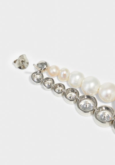 Σκουλαρίκια από πέρλες και κρύσταλλο με εναλλασσόμενες στρογγυλές πέρλες σε διάφορα μεγέθη, με μεταλλικές ρυθμίσεις σε ασημένιο τόνο και κυκλικά κρύσταλλα.