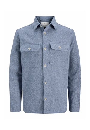 Blå skjorte med knapper laget av teksturert stoff, med to brystlommer, en spiss krage og et subtilt mønster.