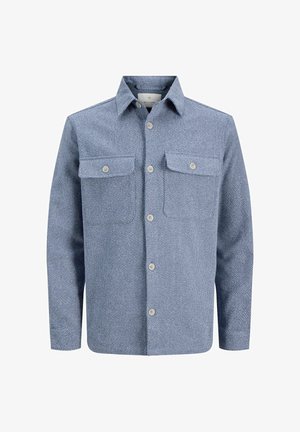 Blå skjorte med knapper laget av teksturert stoff, med to brystlommer, en spiss krage og et subtilt mønster.