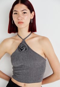 Γκρίζο κοντό halter τοπ με υφή, που διαθέτει λεπτομέρεια σε σχήμα λουλουδιού στο λαιμό και λεπτές τιράντες.