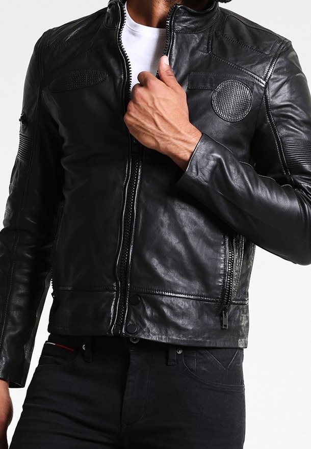 Schwarze Lederjacke mit taillierter Passform, Reißverschluss, runden und strukturierten Akzenten an den Schultern sowie dezenten Steppdetails.