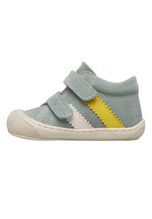 Scarpa da ginnastica per bambino color grigio chiaro con due strisce in Velcro, strisce diagonali bianche e gialle, e suola in gomma bianca testurizzata.