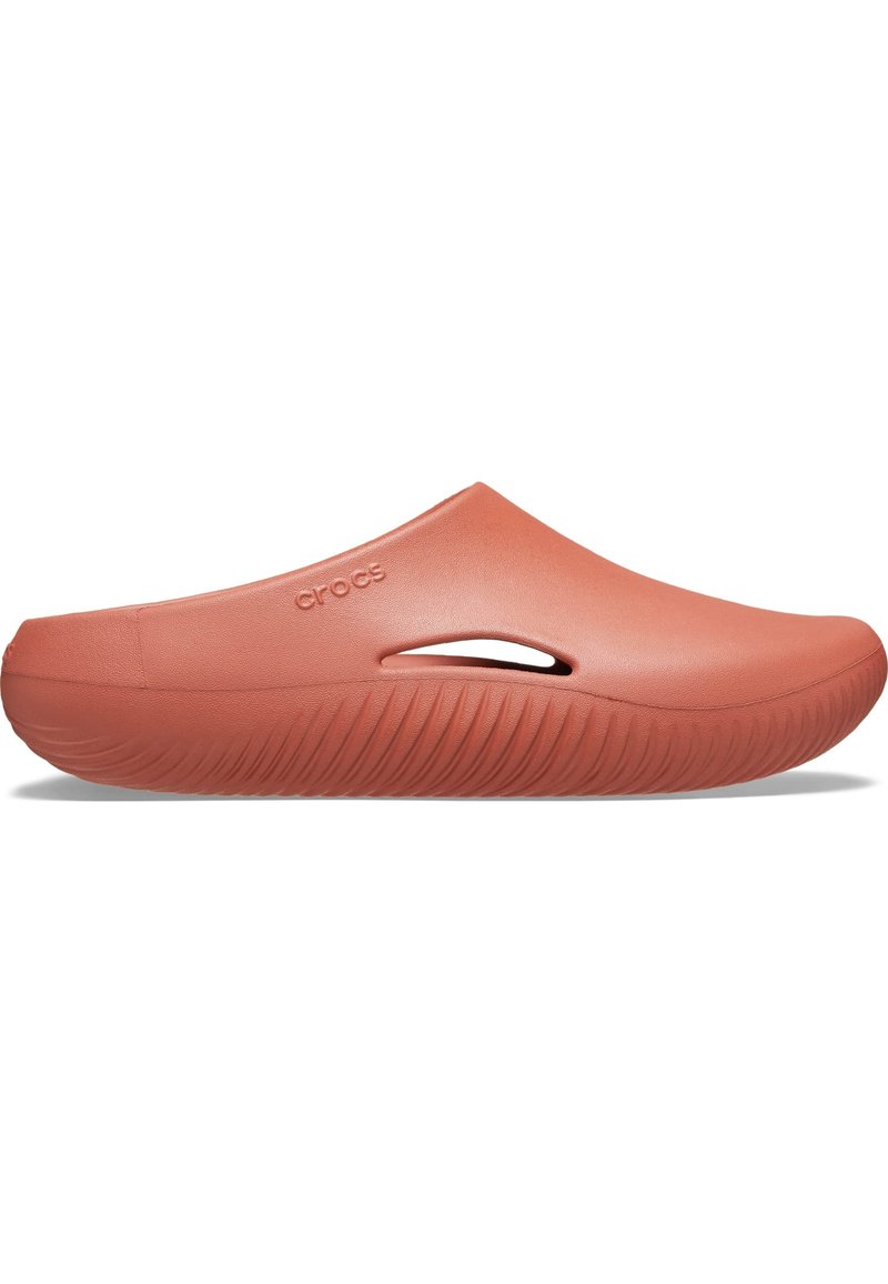 Coral-colored clogs with a smooth matte finish, featuring side ventilation holes and a textured sole for traction. Logo embossed on the side.