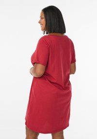 Red cotton t-shirt dress with short sleeves, relaxed fit, round neckline, and above-knee length. Smooth texture, basic design without embellishments.
