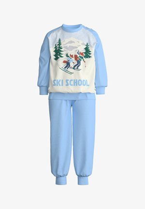 Luchtblauwe sweatpants en bijpassend crewneck met een grafisch ontwerp van skiërs, bomen en bergen met de tekst "SKI SCHOOL" in vet blauw. Zachte stof.